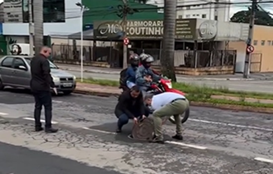 Prefeito Sandro Mabel para o trânsito para recolocar tampa de esgoto